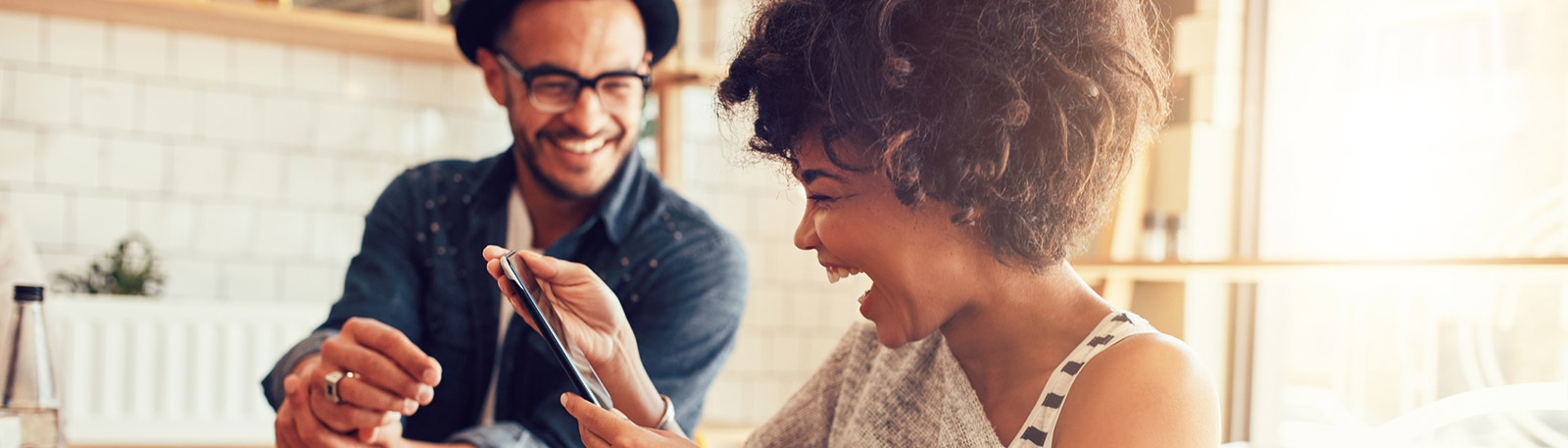 Couple looking at phone in coffee shop